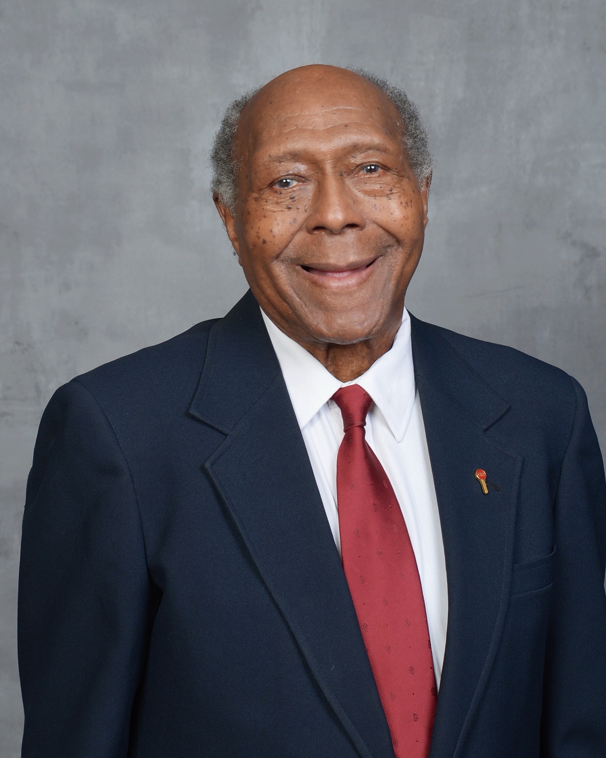 Formal portrait in a navy suit and red tie